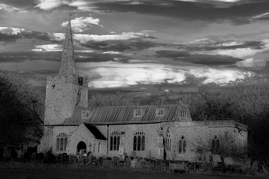 Black and white photo of a country church under a dramatic stormy sky, Suffolk architecture photography