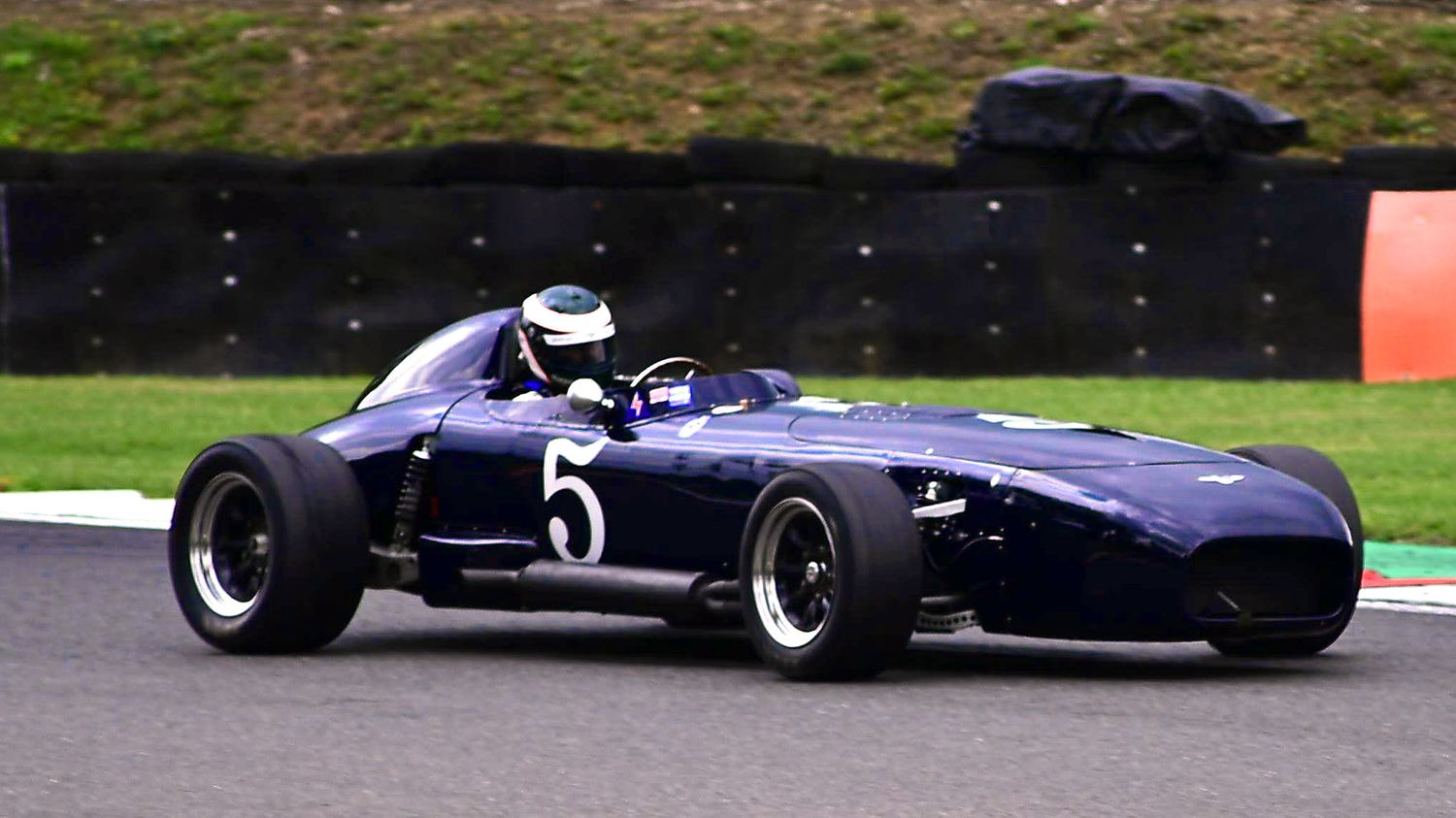 Blue vintage open-wheel race car on track, motorsport photography