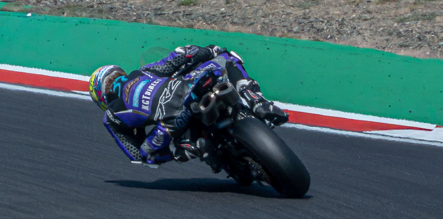 Motorcycle racer leaning into a corner on track, motorsport photography