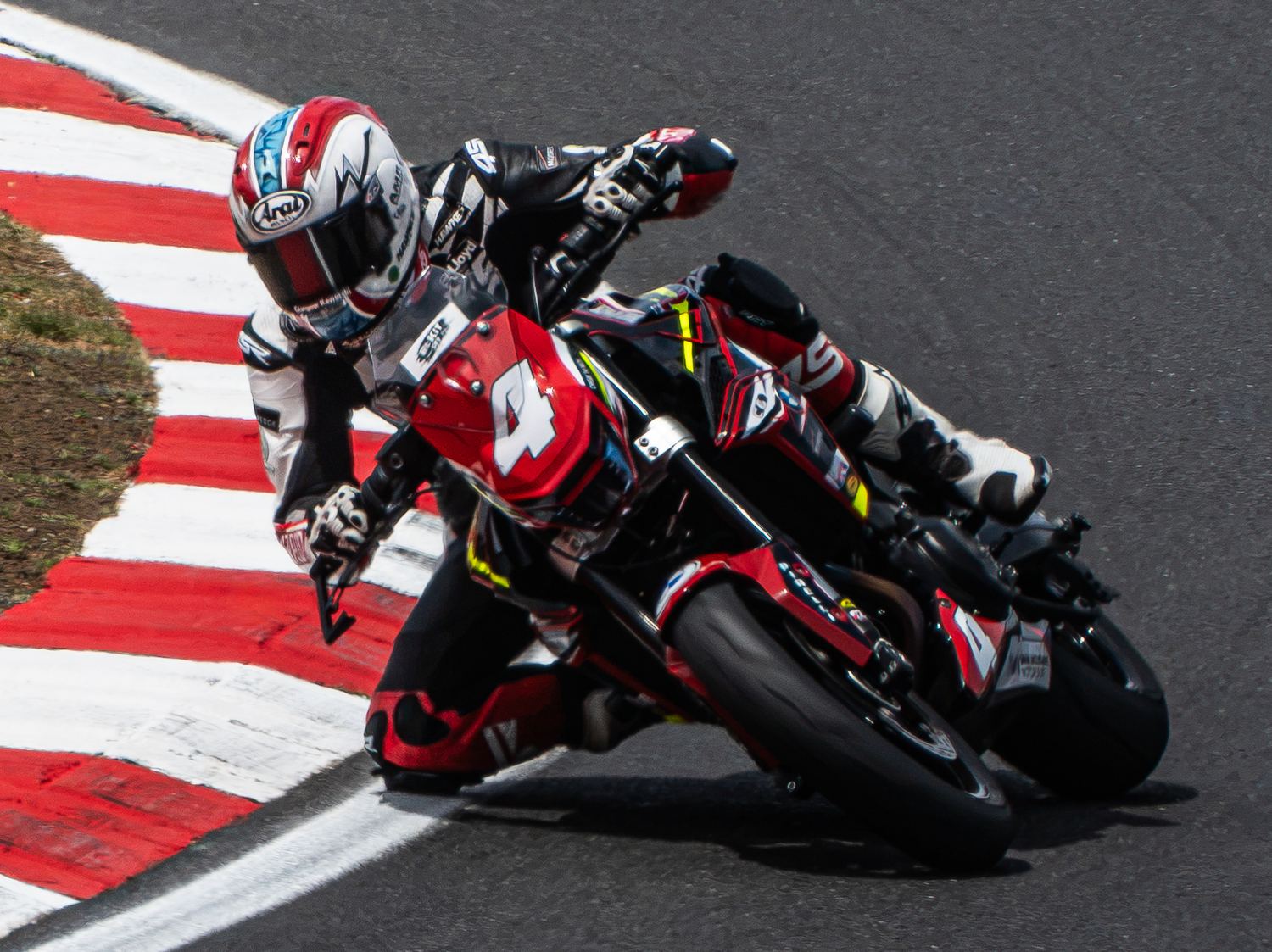 Close-up of a motorcycle racer leaning into a corner, motorsport photography
