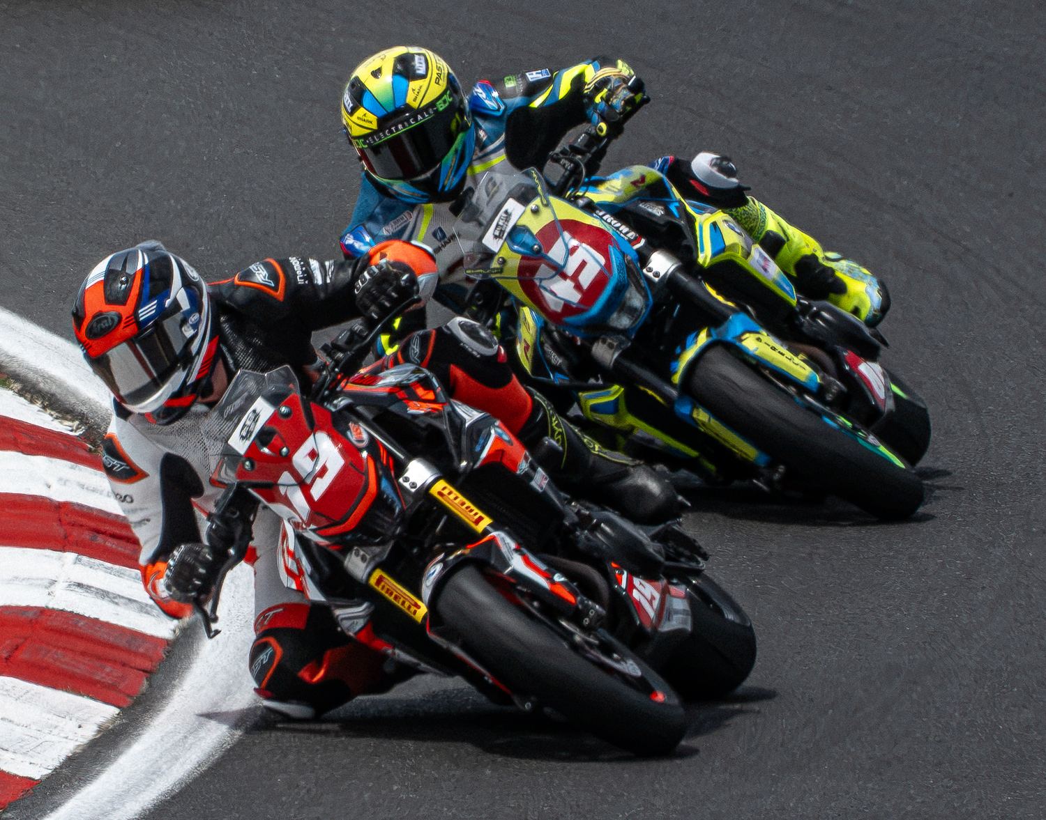 Pack of motorcycle racers battling through a corner, motorsport photography