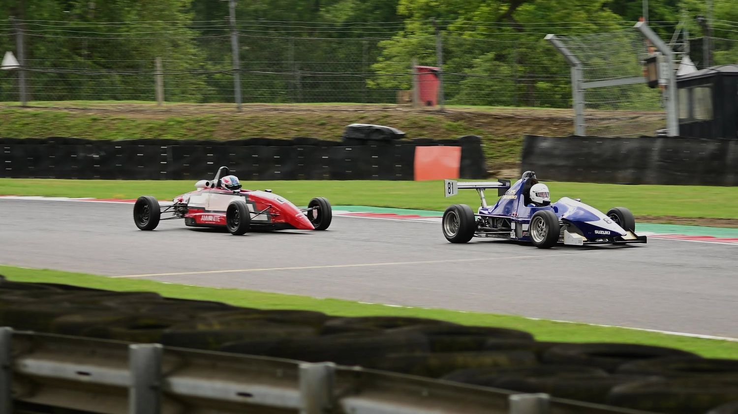 Two single-seater race cars racing side by side, motorsport photography