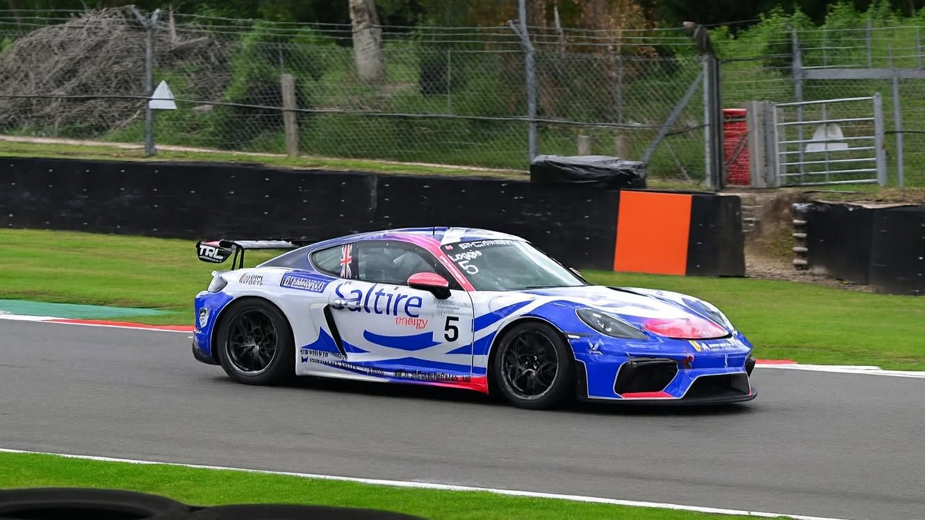 White GT race car cornering on track, motorsport photography