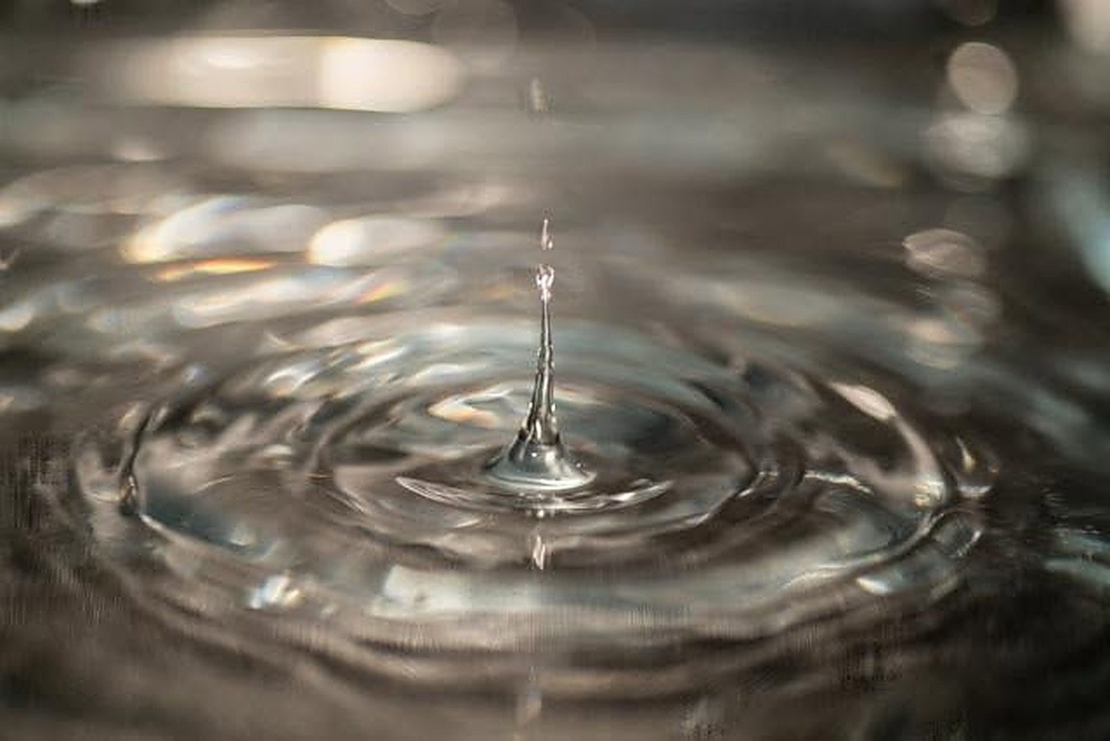 Macro photo of a water droplet splash creating ripples, nature photography