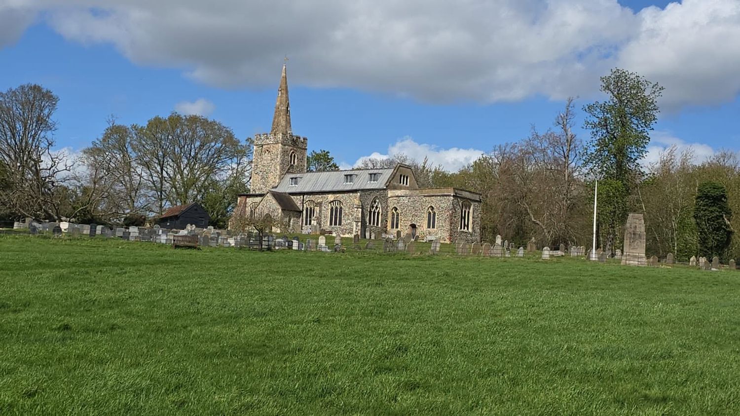 Flint parish church on a village green under blue sky, Suffolk architecture photography