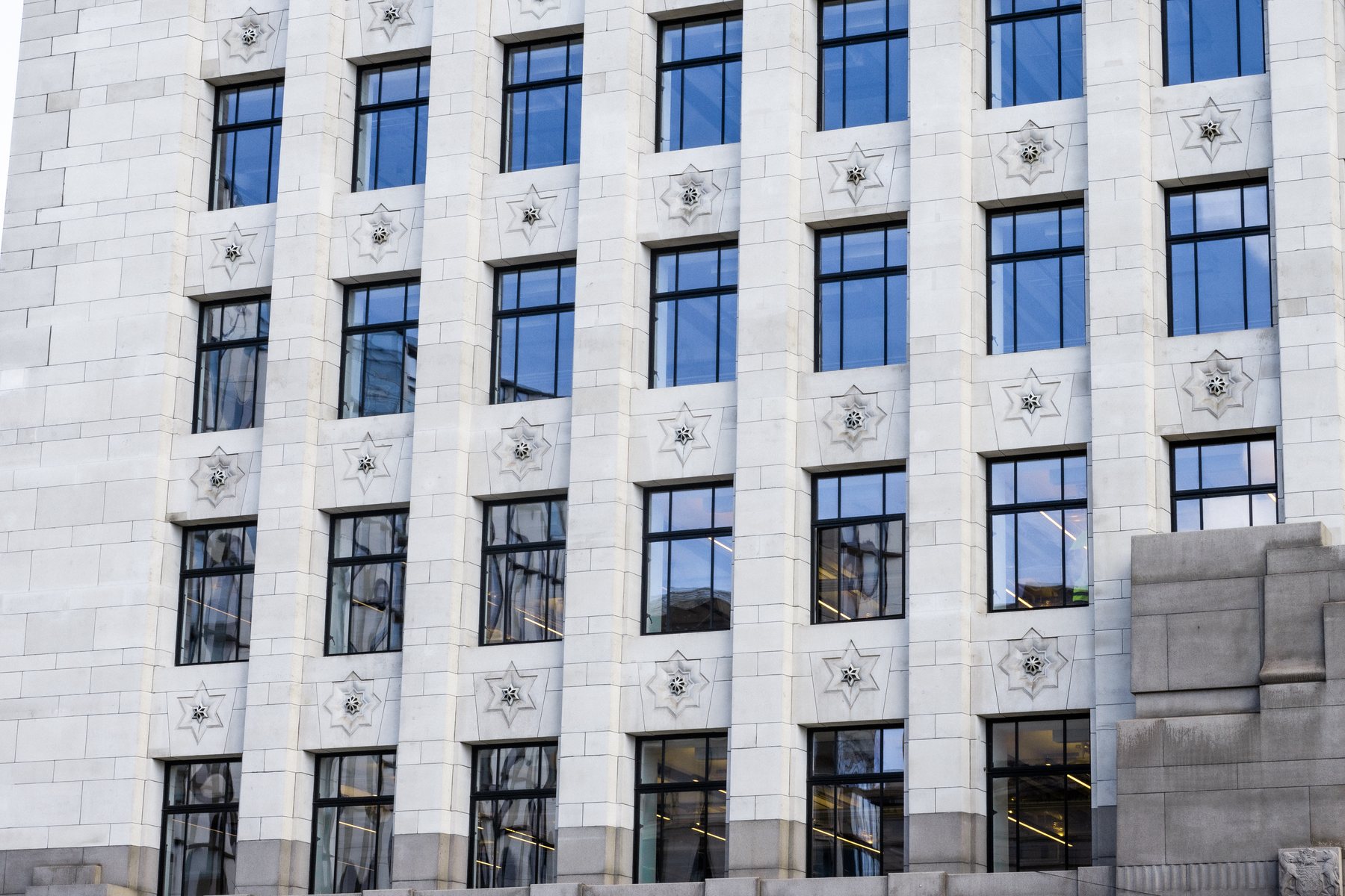 White stone office building facade with grid windows, architecture photography, London