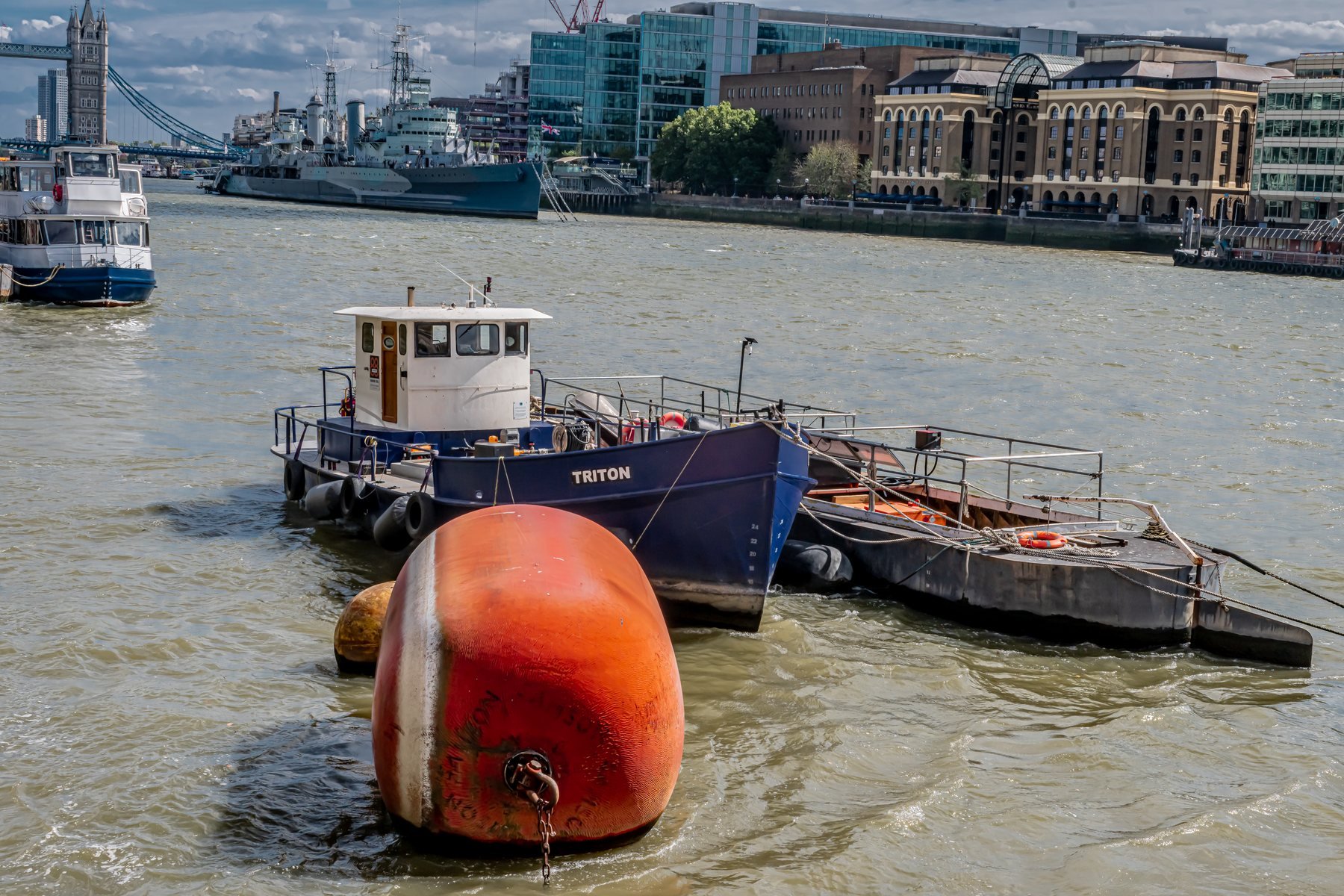 Tugboat and orange mooring buoy on the River Thames, landscape photography, London