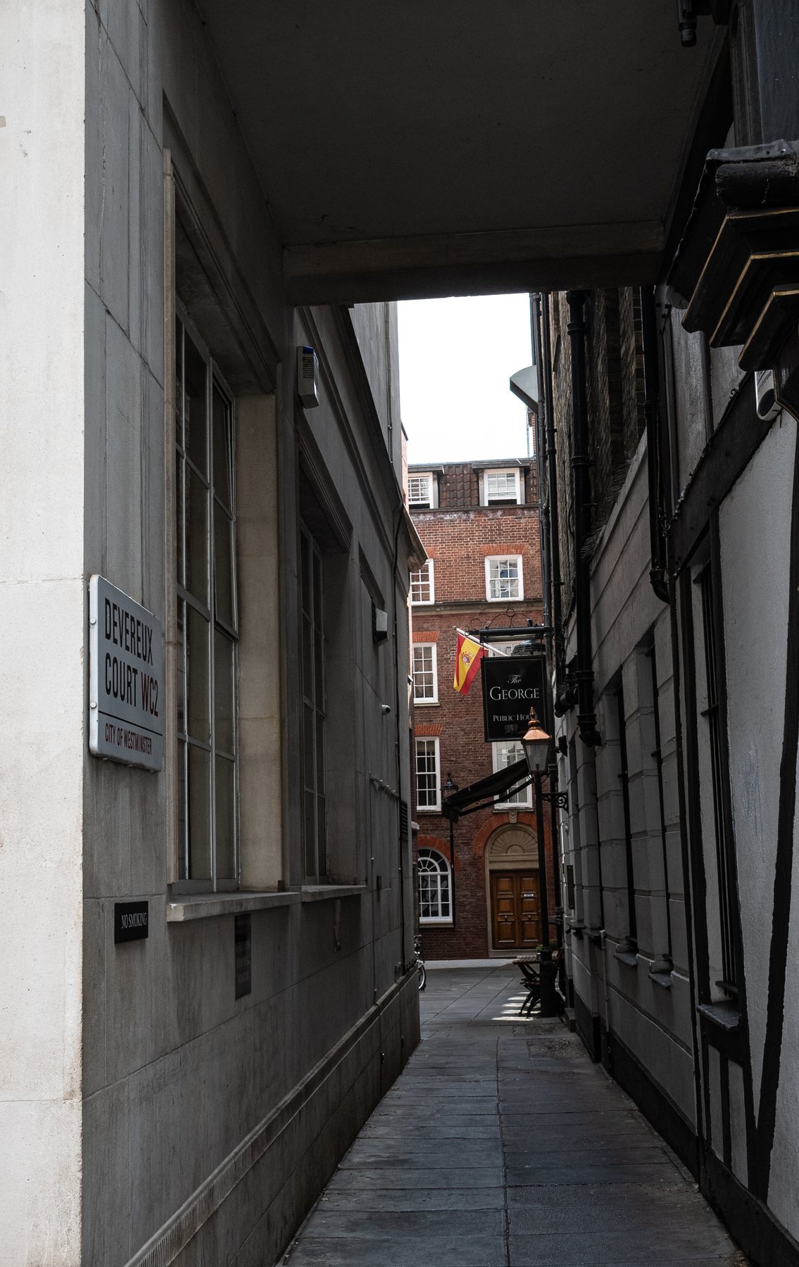 Narrow London alleyway leading to The George Public House, street sign for Devereux Court, architecture photography, London