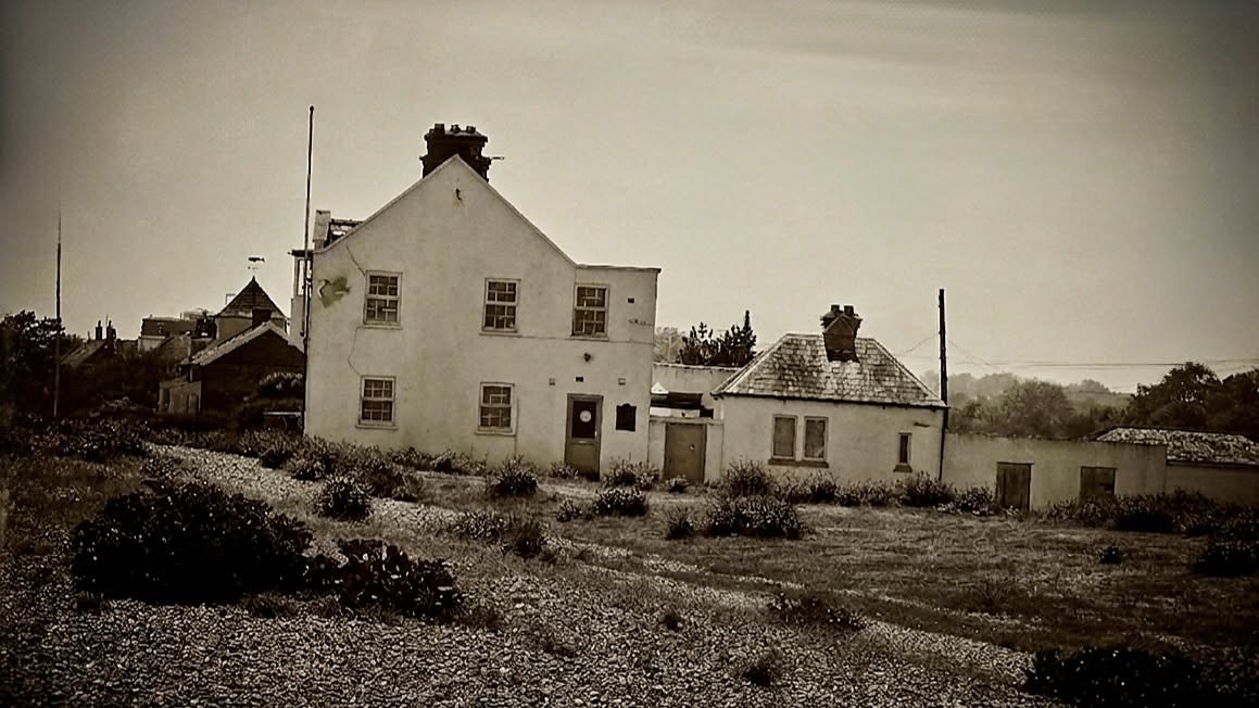 Weathered abandoned coastal house with cracked render, sepia-toned architecture photography