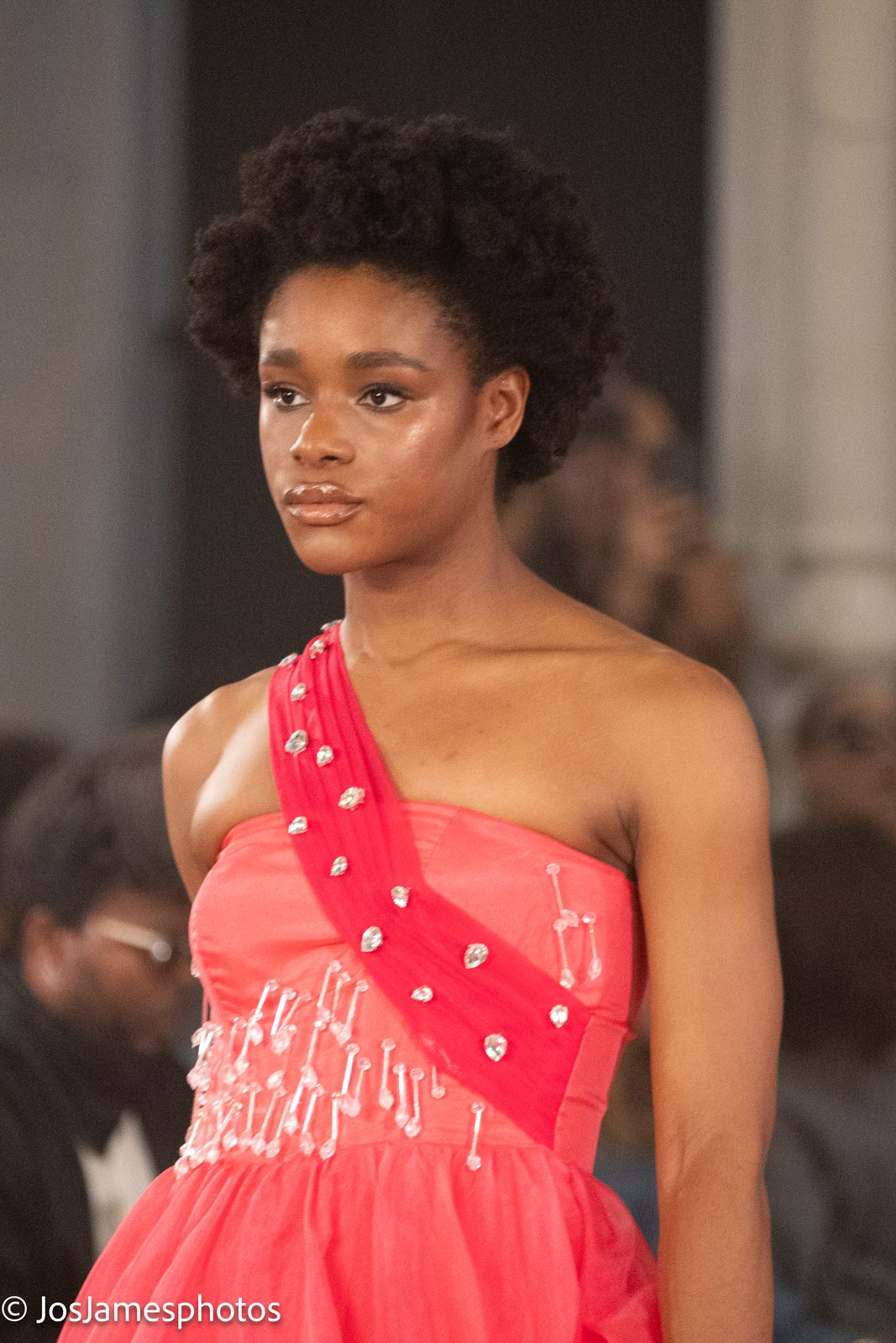 Model in a coral one-shoulder gown on the catwalk, London Fashion Week 2026 event photography