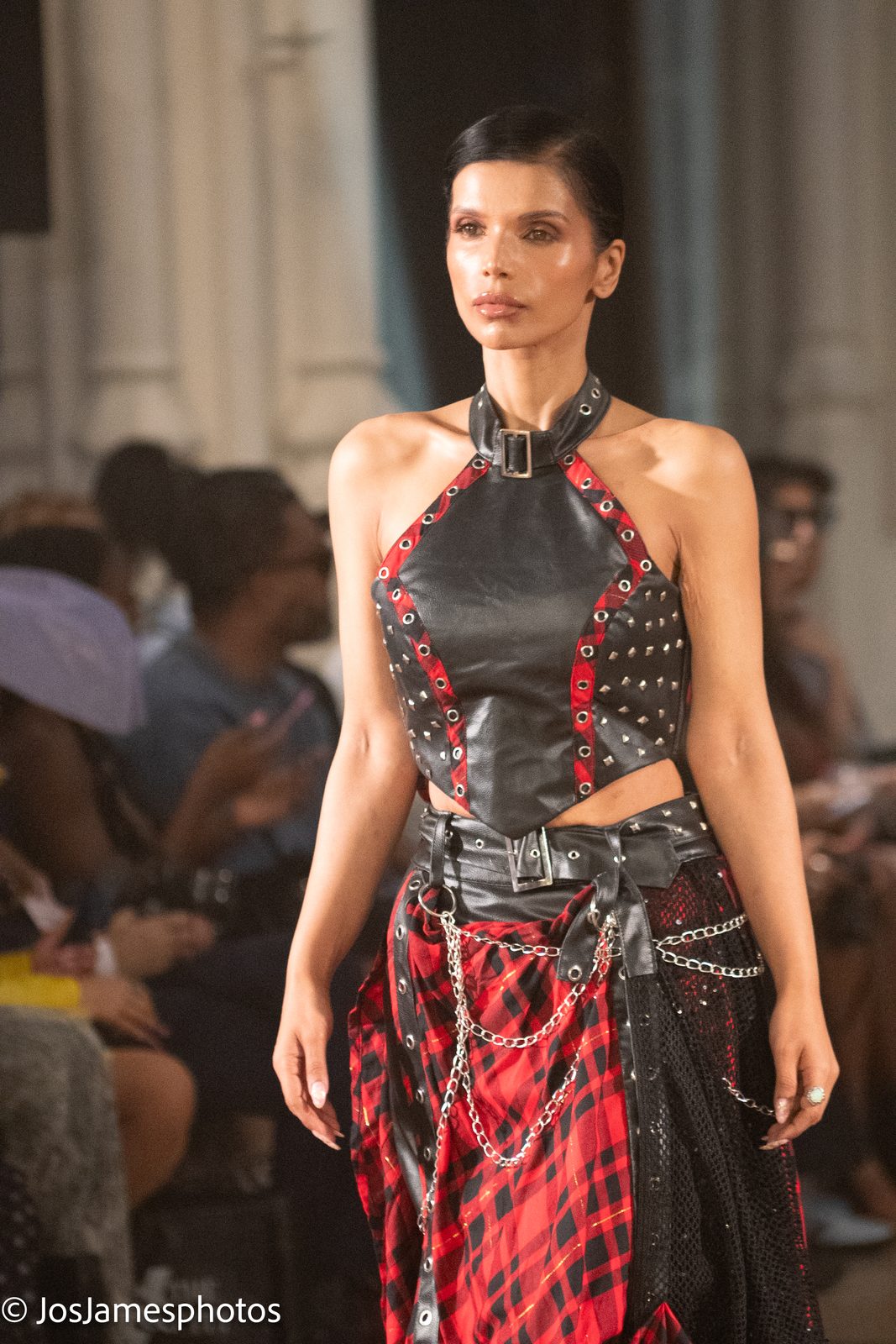 Model in a studded leather halter and tartan skirt on the catwalk, London Fashion Week 2026 event photography