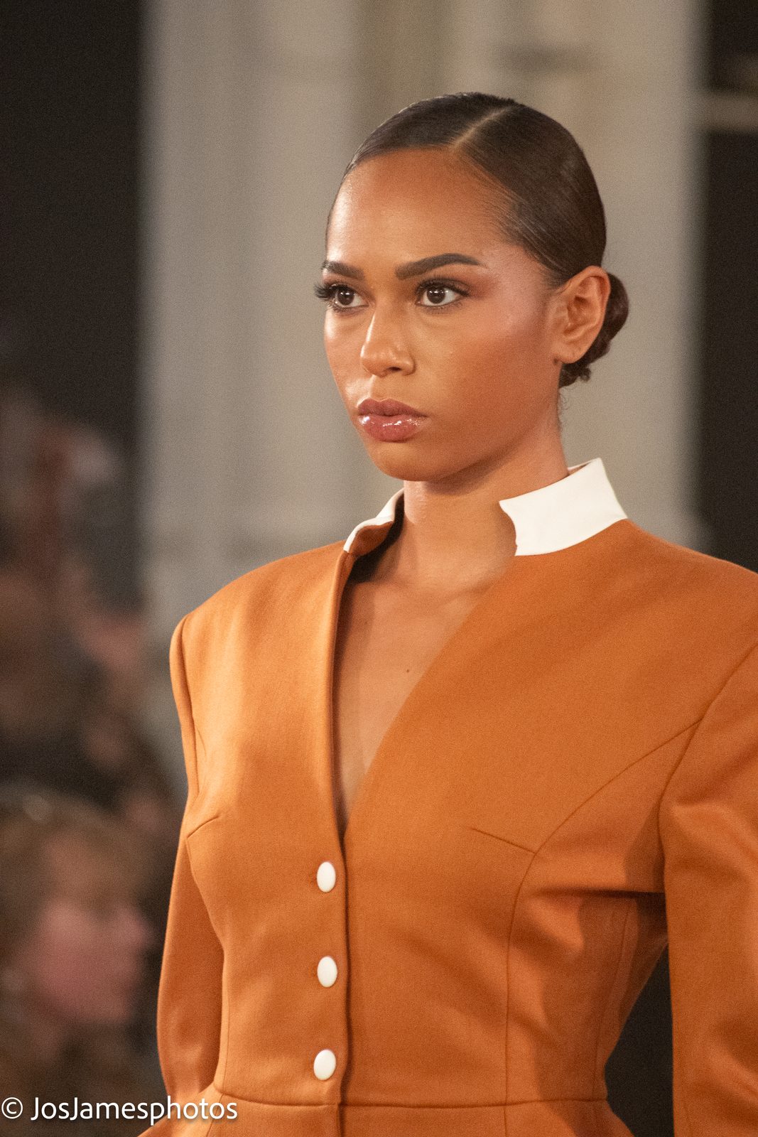 Close-up of a model in an orange tailored jacket, London Fashion Week 2026 event photography