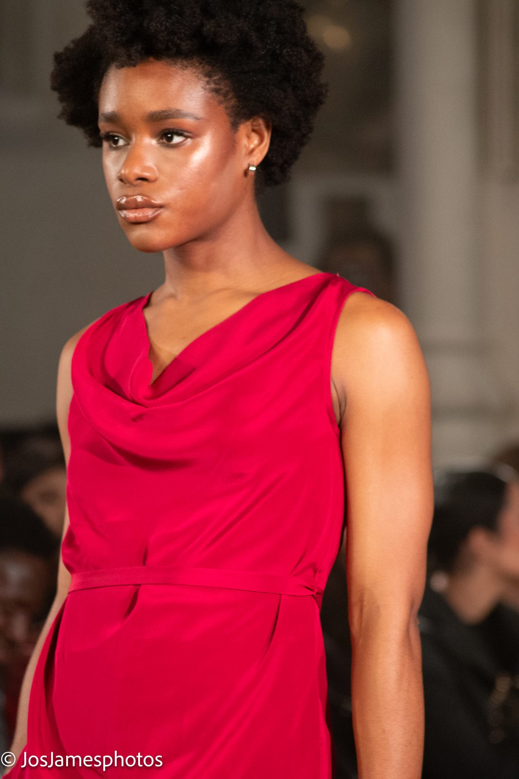 Model in a red draped top on the catwalk, London Fashion Week 2026 event photography