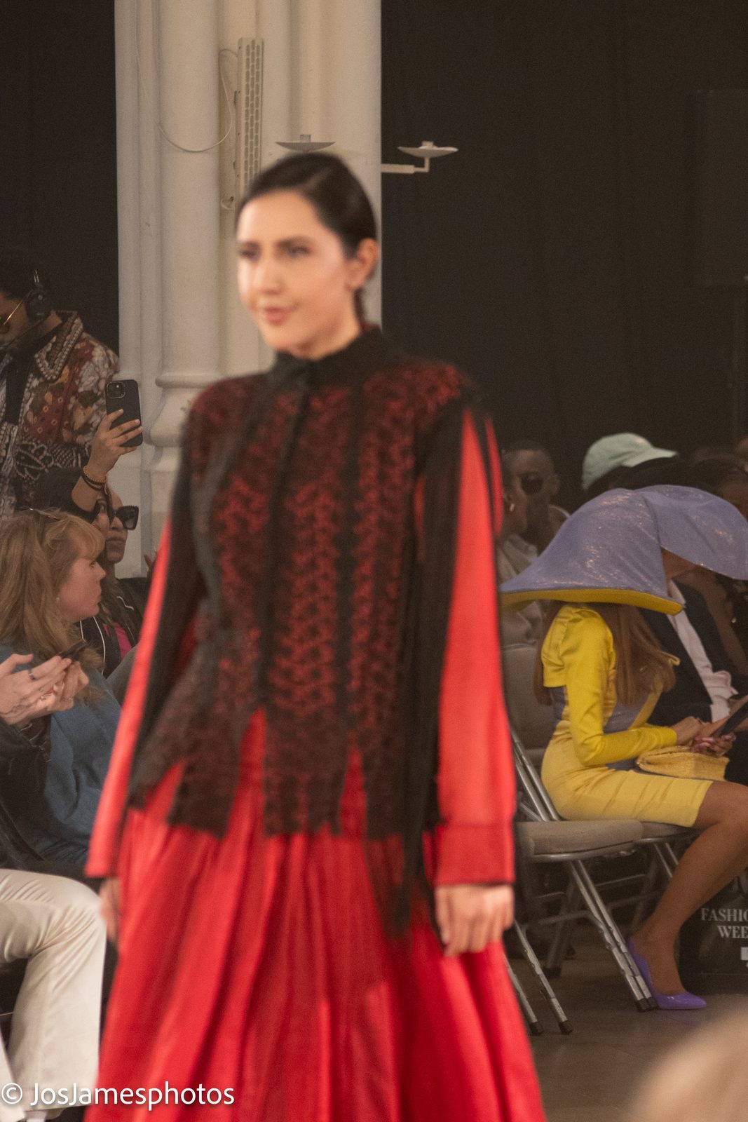 Model in a red and black embroidered outfit on the catwalk, London Fashion Week 2026 event photography