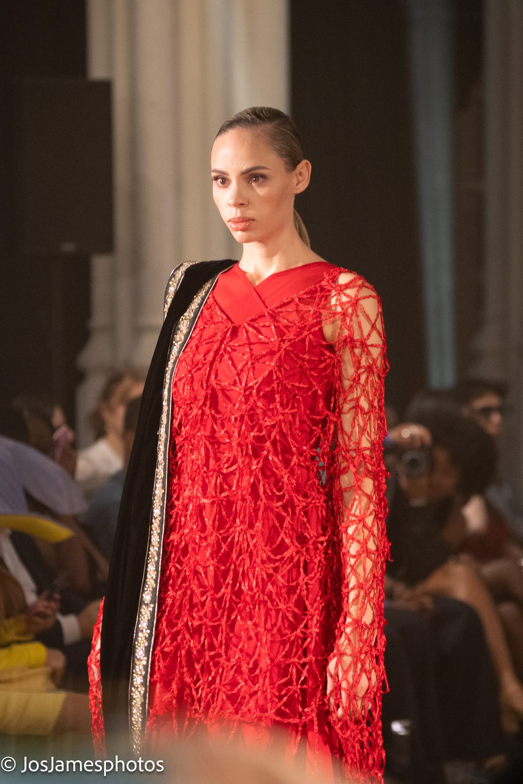Model in a red lattice dress on the catwalk, London Fashion Week 2026 event photography